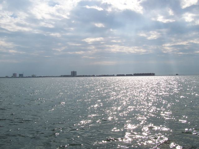 Sun on the water, a far shore of condominiums